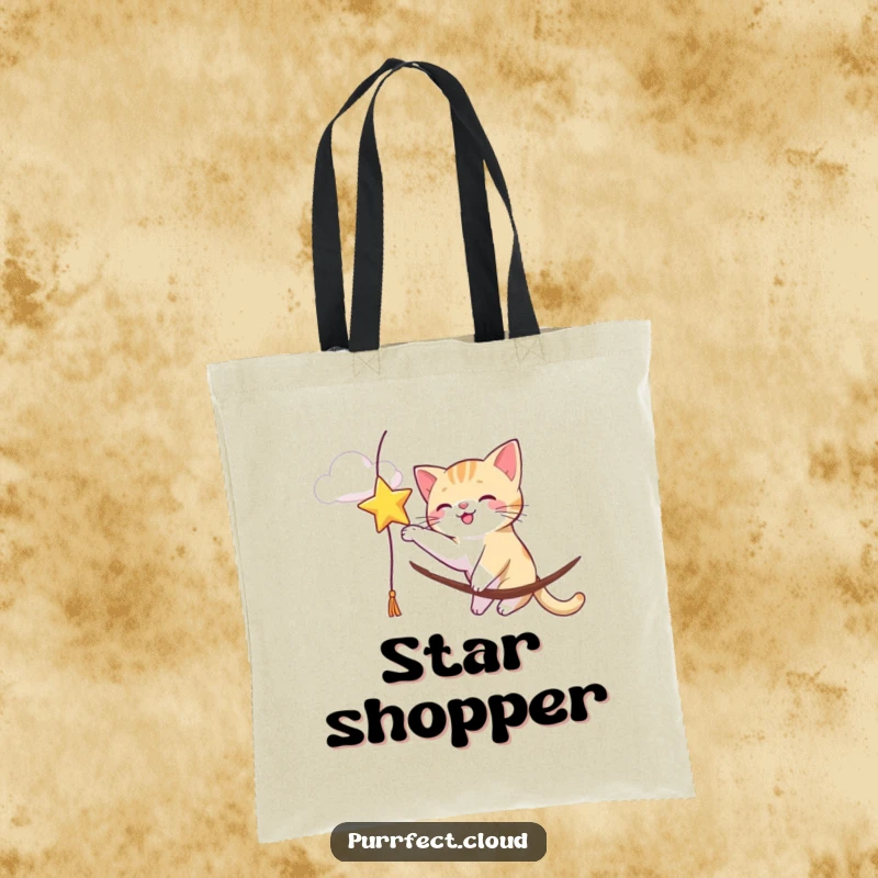 Funny cat enthusiastically batting at a dangling star from a cloud, making this tote bag a playful accessory.